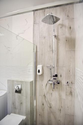 a bathroom with a shower with a toilet and an umbrella at Pokoje Gościnne & Apartamenty Przemyk in Rewa