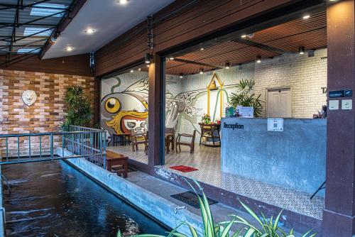 une maison avec une piscine et un tableau sur le mur dans l'établissement Tarnsiri Boutique Resort, à Kanchanaburi