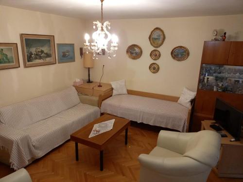 a living room with two couches and a chandelier at Senia Retro in Senj
