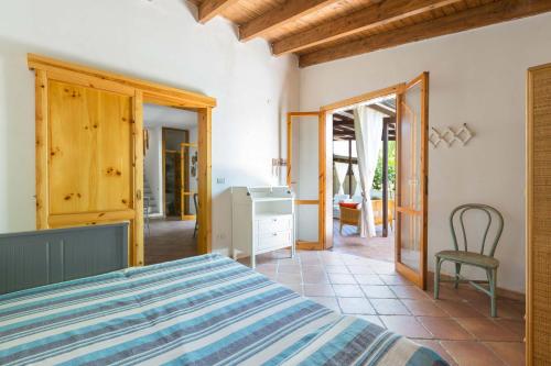 ein Schlafzimmer mit einem Bett und einem Stuhl in einem Zimmer in der Unterkunft Villino Pepe Rosa by BarbarHouse in Torre dell'Orso