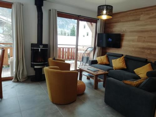 uma sala de estar com um sofá e um fogão a lenha em Chalet Rivendell, Morzine sleeps 10 with garage em Morzine