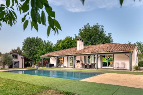 une maison avec une piscine devant une maison dans l'établissement Villa 'La Crabichonnière', à Lanzac