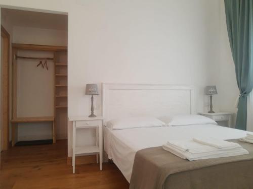 1 dormitorio con cama blanca y mesa en Henry Agriturismo Manfredonia en Ippocampo