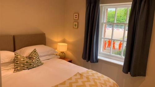 a bedroom with a bed and a window at Oulton Park Lodge in Little Budworth
