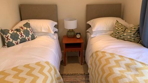 two twin beds in a room with a night stand at Oulton Park Lodge in Little Budworth