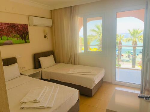 um quarto de hotel com duas camas e vista para o oceano em Holiday Hotel em Kusadası