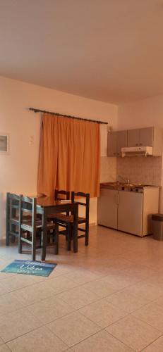 a dining room with a table and a kitchen at Georgia in Léntas
