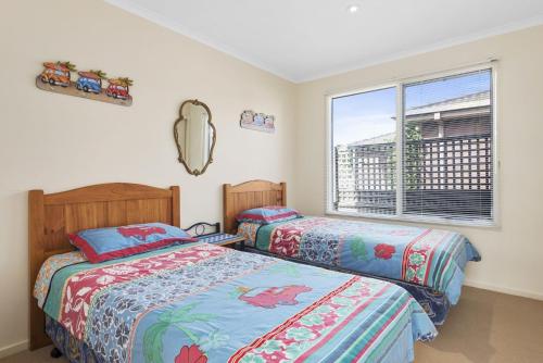 2 łóżka w sypialni z oknem w obiekcie Budget By The Bay w mieście Apollo Bay