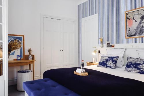 a bedroom with a bed and a blue chair at Le Flaubert in Trouville-sur-Mer