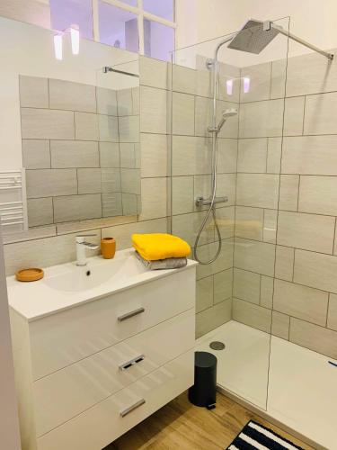 a bathroom with a shower with a yellow towel on a sink at Sur les quais... in Arles