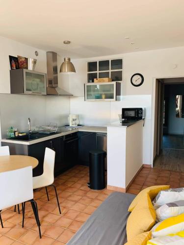 une cuisine et un salon avec une table et un canapé dans l'établissement Sur les quais..., à Arles