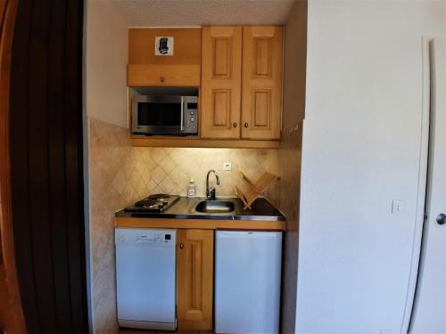 eine kleine Küche mit einer Spüle und einer Mikrowelle in der Unterkunft Studio Les Menuires, 1 pièce, 3 personnes - FR-1-452-50 in Les Menuires