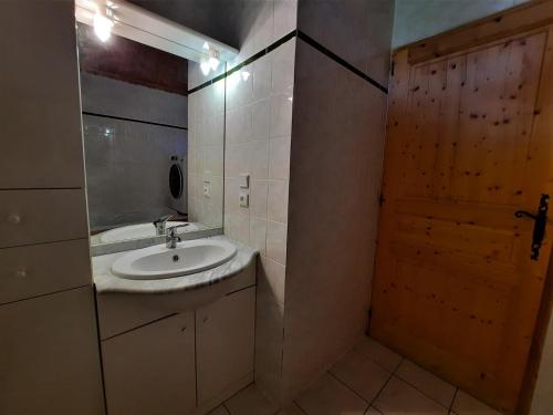 un bagno con lavandino, specchio e porta di Appartement Les Menuires, 4 pièces, 12 personnes - FR-1-452-86 a Les Menuires