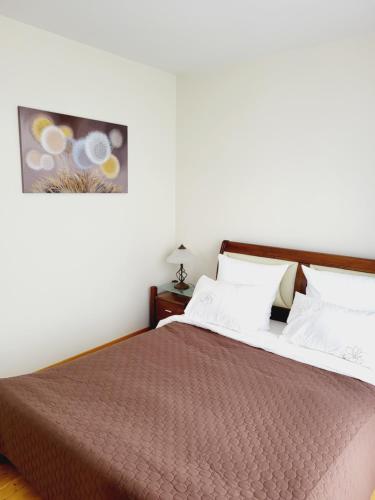 1 dormitorio con 1 cama grande con manta marrón en Smilgose, en Palanga