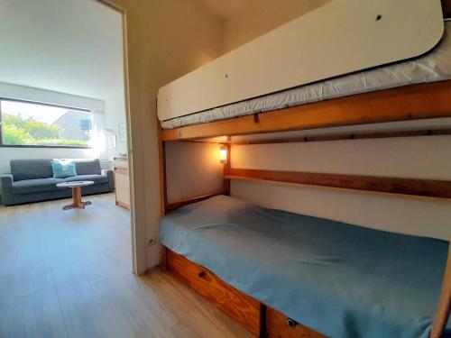 - une chambre avec 2 lits superposés et un canapé dans l'établissement Carnac : Studio Cabine avec Piscine chauffée, proche Plage et Thalasso, Animaux bienvenus - FR-1-477-186, à Carnac
