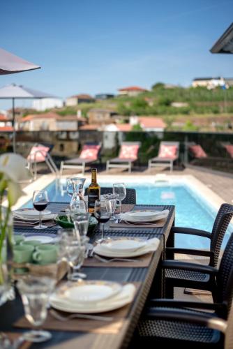 a table with glasses and wine bottles on top of a patio at Casa Dona Maria - Armamar Douro in Armamar