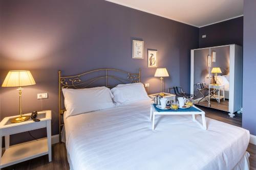 a bedroom with a large white bed with a blue tray on it at Borgo Le Terrazze in Bellagio