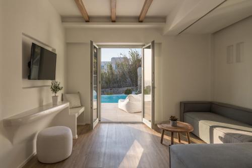 a living room with a couch and a tv at Arocaria Mykonos in Mýkonos City