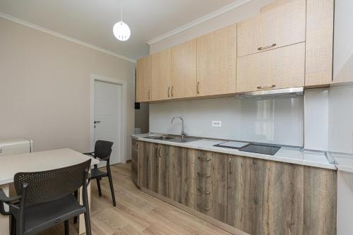 a kitchen with wooden cabinets and a table and chairs at Curoj Luxury Apartments in Radhimë