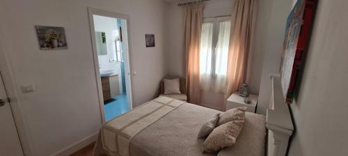 - une petite chambre avec un lit et un miroir dans l'établissement PRECIOSO ATICO EN CENTRO CIUDAD, à San Fernando