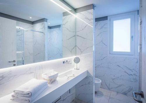 a white bathroom with a sink and a shower at Borgo Le Terrazze in Bellagio