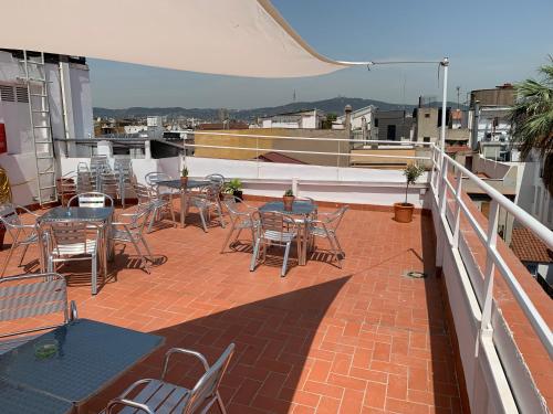 a patio with tables and chairs on a roof at Hostal La Terrassa in Barcelona