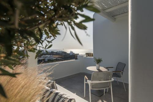 a room with a table and chairs on a balcony at Arocaria Mykonos in Mýkonos City