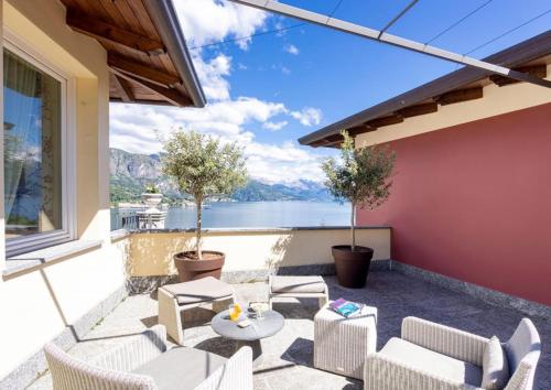 a patio with chairs and tables and a view of the water at Borgo Le Terrazze in Bellagio