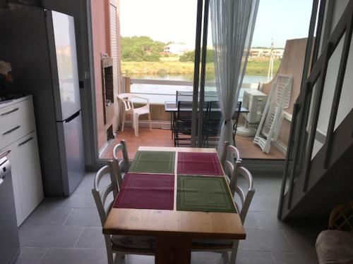 - une table et des chaises dans une chambre avec vue sur la cuisine dans l'établissement Marins 305, à Saint-Cyprien