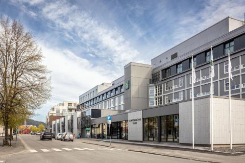 un gran edificio en una calle con coches aparcados fuera en Quality Airport Hotel Værnes en Stjoerdal
