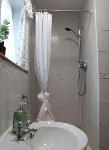 a bathroom with a shower and a white sink at Holly Lodge Country Guest House in Blidworth