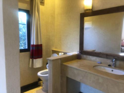 a bathroom with a sink and a toilet and a mirror at Villa Atlas Secret in Ourika