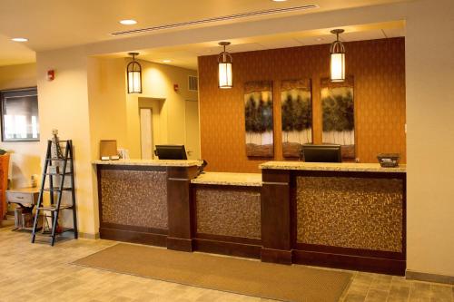 a hotel lobby with a bar with two lights at Little Missouri Inn & Suites Watford City in Watford City