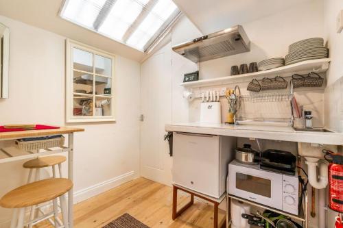 a kitchen with a sink and a stove at The Artists Workshop - Norfolk Holiday Properties in Norwich