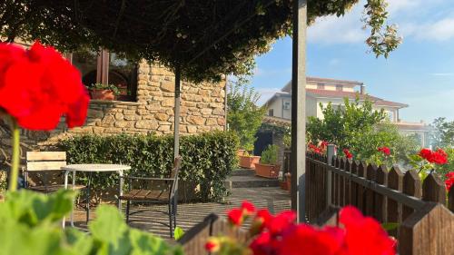 - une terrasse avec une table, des chaises et des fleurs dans l'établissement Antico Casale da Gemma, à Fuscaldo