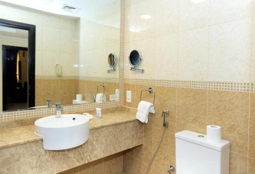 a bathroom with a sink and a mirror at Ivory Grand Hotel Apartments in Dubai