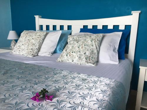a bedroom with a white bed with blue walls at Great sea-view apartment. in Khóra Sfakíon