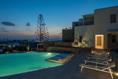 a villa with a swimming pool at night at Arocaria Mykonos in Mýkonos City