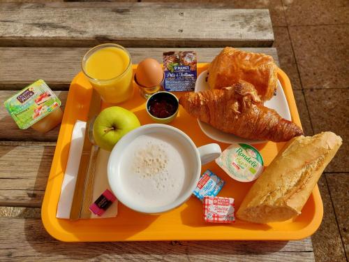 an orange tray with breakfast food on a table at Premiere Classe Saintes in Saintes