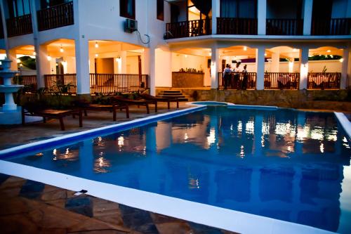 馬特姆維的住宿－Zanoceanique Hotel，一座游泳池,在晚上在建筑物前