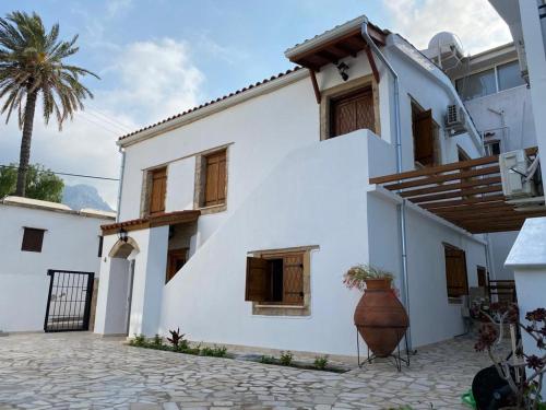 a white house with a palm tree in the background at Templos Homes in Kérynia