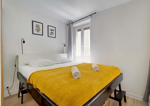 ein Schlafzimmer mit einem Bett mit zwei Handtüchern darauf in der Unterkunft L'HYPERCENTRE de Suresnes in Suresnes