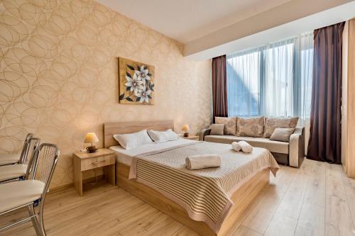 um quarto de hotel com uma cama e um sofá em Studio Apartment NFT New Gudauri 108 em Gudauri