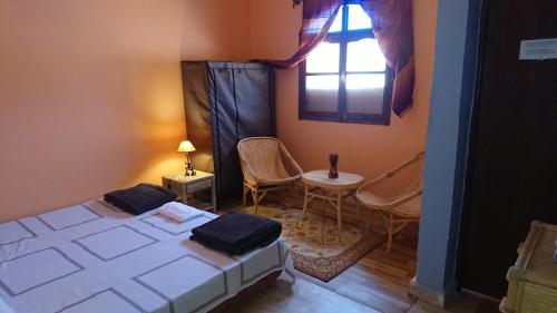 a room with two beds and a table and a window at Aziki in Essaouira