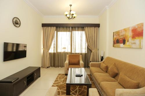 a living room filled with furniture and a couch at Ivory Grand Hotel Apartments in Dubai