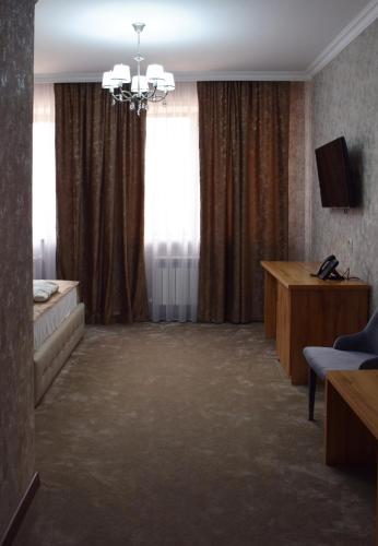 a living room with a couch and a window at MirOtel Hotel in Astana