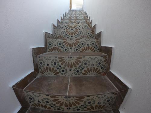 a set of stairs with intricate tile on them at Templos Homes in Kérynia