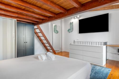 a bedroom with a large bed and a flat screen tv at THE SAILOR HOUSE, Duplex Palma Center in Palma de Mallorca