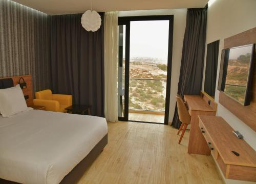 ein Hotelzimmer mit einem Bett und einem großen Fenster in der Unterkunft Surf One Hotel in Agadir