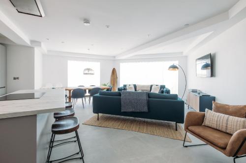a living room with a blue couch and chairs at Luxury Family Apartment with sea views in Newquay